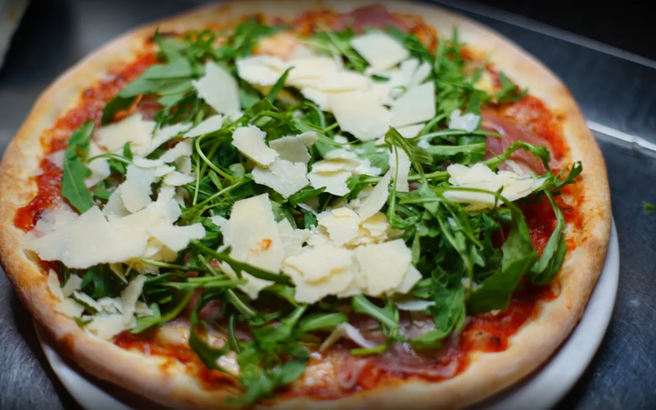 Pizza mit Ruccola und Parmesan